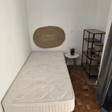 Habitación individual con colchón y estantería